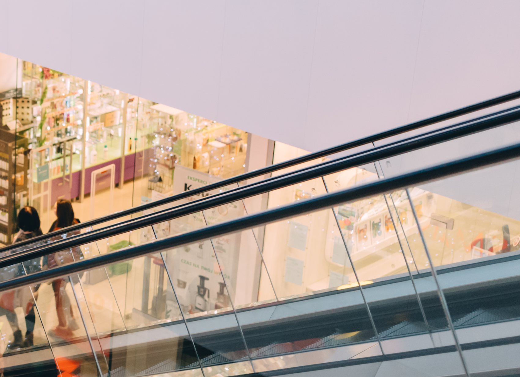 Retail store reflected in mall escalator glass